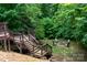 Backyard space showcasing a lower level deck area, stairs, and a stone fire pit surrounded by chairs at 6398 Winding Creek Ln, Denver, NC 28037