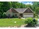 Charming single-story home with mature landscaping, an American flag, and a two-car garage at 6398 Winding Creek Ln, Denver, NC 28037