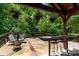 Outdoor patio with bar seating, dining area, fire pit, and lush wooded views and shade at 6398 Winding Creek Ln, Denver, NC 28037