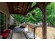 Outdoor patio with bar seating, dining area, water feature, and lush wooded views and shade at 6398 Winding Creek Ln, Denver, NC 28037