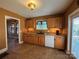 Kitchen featuring wooden cabinets, tiled floor, and modern appliances, including a white dishwasher for convenience at 66 Arlington Se Ave, Concord, NC 28025