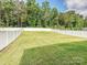 Expansive, well-maintained backyard with a white fence and lush green grass at 665 Pointe Andrews Dr, Concord, NC 28025