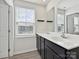 A bathroom featuring double sinks with a large mirror and window at 665 Pointe Andrews Dr, Concord, NC 28025