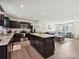 Open-concept kitchen with stainless steel appliances, granite countertops, dark cabinets, and bar stool seating at 665 Pointe Andrews Dr, Concord, NC 28025
