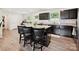 Kitchen island with granite countertops, black cabinets, and bar stool seating, complemented by natural light at 665 Pointe Andrews Dr, Concord, NC 28025