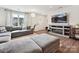Cozy living room featuring a sectional sofa, modern decor, and entertainment center with a fireplace at 665 Pointe Andrews Dr, Concord, NC 28025