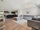 Open-concept living room featuring a large sectional sofa, modern lighting, and sleek black kitchen cabinets at 665 Pointe Andrews Dr, Concord, NC 28025