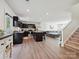 Bright, open-concept living space with dark kitchen cabinets, stainless steel appliances, and a comfortable lounge area at 665 Pointe Andrews Dr, Concord, NC 28025