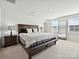 Spacious main bedroom featuring a bed, bench and large mirror at 665 Pointe Andrews Dr, Concord, NC 28025