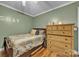 A quaint bedroom features a cozy bed, a dresser, and green colored walls at 725 Hunters Ridge Rd, Taylorsville, NC 28681