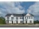 New white townhome exteriors feature a gray roof, stone accents, and black shutters at 7631 Griffins Gate Sw Dr, Concord, NC 28025