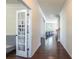 Hallway with beautiful hardwood floors leading to the living room and a glass door enclosed office at 7711 Kelburn Ln, Charlotte, NC 28273