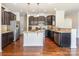 Kitchen with granite countertops, stainless steel appliances, dark cabinets, and hardwood flooring at 7711 Kelburn Ln, Charlotte, NC 28273