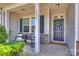 Inviting covered front porch with seating, columns, and decorative door with wreath at 8853 Brakeman Dr, Waxhaw, NC 28173