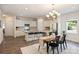 A spacious, modern kitchen with white cabinetry, stainless steel appliances, and a dining area with an elegant chandelier at 8853 Brakeman Dr, Waxhaw, NC 28173