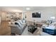 Spacious living room with modern sofas, a large TV, and an open layout to the kitchen and dining area at 8853 Brakeman Dr, Waxhaw, NC 28173