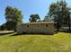 Exterior rear view of the home with a large yard, mature trees, and blue sky at 910 Absher Rd, Statesville, NC 28625