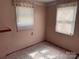 Empty bedroom with paneled walls and carpet, featuring two windows at 910 Absher Rd, Statesville, NC 28625