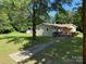 Exterior home view with a sidewalk, large trees, and green yard at 910 Absher Rd, Statesville, NC 28625
