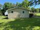 Exterior side view of the home with a large yard, mature trees, and clear sky at 910 Absher Rd, Statesville, NC 28625