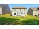 A spacious backyard featuring a patio, fire pit, and well-manicured lawn at 9301 Swimming Dr, Harrisburg, NC 28075