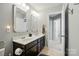 Bathroom featuring double sink vanity, framed mirrors, and linen closet at 9301 Swimming Dr, Harrisburg, NC 28075