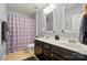 Bathroom featuring double sink vanity, framed mirrors, and shower with patterned curtain at 9301 Swimming Dr, Harrisburg, NC 28075