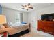 Bedroom featuring stylish bed, dresser with television, and ceiling fan at 9301 Swimming Dr, Harrisburg, NC 28075