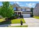 Charming two-story home boasts a brick and siding exterior, attached two-car garage, and a well-manicured front yard at 9301 Swimming Dr, Harrisburg, NC 28075
