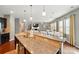 Open concept kitchen with granite counters, stainless appliances, and breakfast bar overlooking the living area at 9301 Swimming Dr, Harrisburg, NC 28075