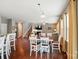 Spacious open-concept living area with hardwood floors, a fireplace, and an adjacent dining area and staircase at 9301 Swimming Dr, Harrisburg, NC 28075