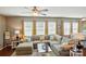 Comfortable living room features an oversized sectional sofa, ceiling fan, and sunny windows at 9301 Swimming Dr, Harrisburg, NC 28075