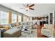 Open-concept living room with hardwood floors, a large sectional sofa, and views into the kitchen, ideal for modern living at 9301 Swimming Dr, Harrisburg, NC 28075