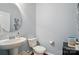Well-lit powder room with pedestal sink, updated fixtures, modern accents, and neutral paint at 9301 Swimming Dr, Harrisburg, NC 28075
