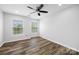 This bedroom has wood floors, a ceiling fan, and large windows for lots of natural light at 9647 Laurie Nw Ave, Concord, NC 28027