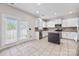 Bright and airy kitchen featuring white cabinets, stainless appliances, a center island, and access to the backyard at 9647 Laurie Nw Ave, Concord, NC 28027