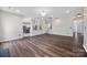 Spacious living room with hardwood floors adjacent to a modern kitchen with stainless appliances and granite counters at 9647 Laurie Nw Ave, Concord, NC 28027