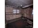Interior shot of a kitchen with worn cabinets, damaged walls, and a deteriorated ceiling at 1015 Frederick St, Shelby, NC 28150