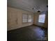 Aged living room featuring hardwood floors, windows with blinds, and a damaged ceiling at 1015 Frederick St, Shelby, NC 28150