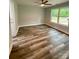 This bedroom features hardwood floors, neutral walls, a ceiling fan, and a window letting in natural light at 1050 Beaten Path Rd, China Grove, NC 28023