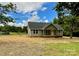 Inviting single-story house featuring green siding, covered entryway, and a spacious yard with trees at 1050 Beaten Path Rd, China Grove, NC 28023