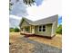 Attractive one-story home with green siding, brick foundation, and covered porch, complemented by gravel walkway at 1050 Beaten Path Rd, China Grove, NC 28023