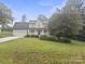 Traditional two-story home with covered porch and landscaped yard on a lush green lawn at 10749 Kingsview Dr, Davidson, NC 28036