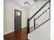 Inviting foyer with hardwood floors, black staircase railing, and a stylish front door at 10749 Kingsview Dr, Davidson, NC 28036
