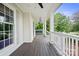 Relaxing front porch features white railings, ceiling fans, stained wood flooring and outdoor furniture at 10749 Kingsview Dr, Davidson, NC 28036