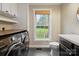 Functional laundry room with a window, black and white patterned tile flooring, washer and dryer at 10749 Kingsview Dr, Davidson, NC 28036