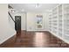 Bright and airy living area features hardwood floors, built-in bookshelves, and front door at 10749 Kingsview Dr, Davidson, NC 28036