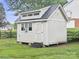 Exterior view of storage building in a well-maintained yard with a cottage-style design and charming details at 10749 Kingsview Dr, Davidson, NC 28036