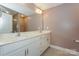 Bathroom featuring dual sinks with marble countertops, a large mirror, and modern lighting at 110 Synandra Dr # B, Mooresville, NC 28117