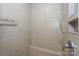 Tiled shower with an adjustable shower head and built-in shelving for convenience at 110 Synandra Dr # B, Mooresville, NC 28117